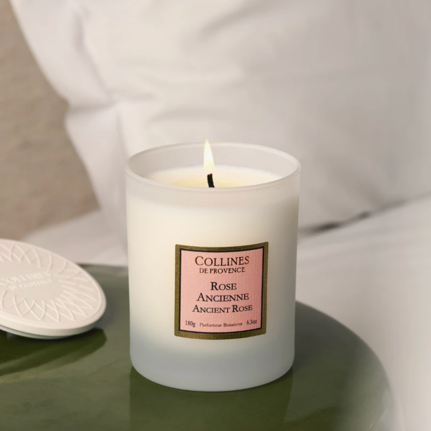 Collines de Provence Ancient rose scented candle, on a side table