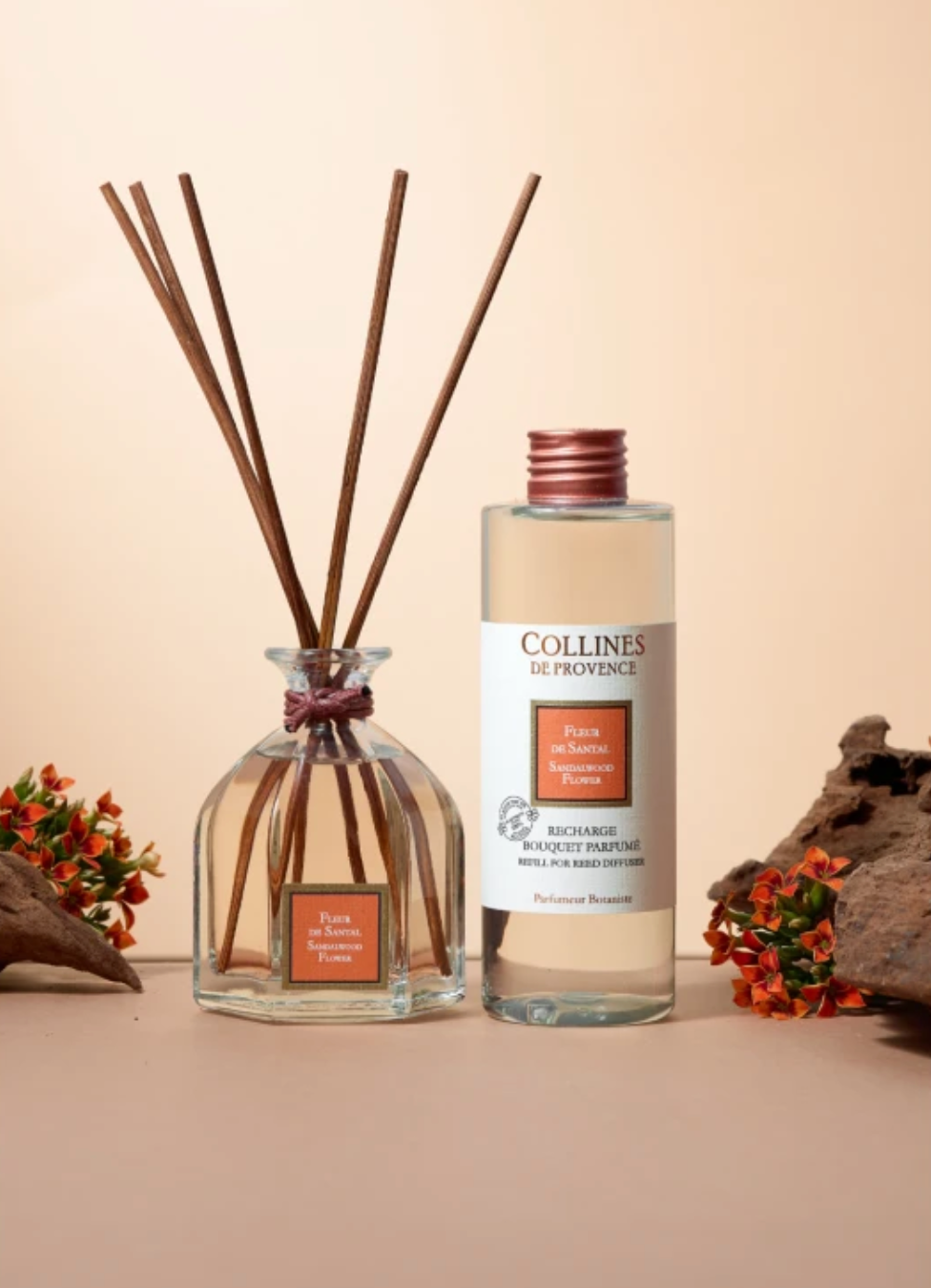 Collines de Provence sandalwood flower diffuser bottle with reeds and refill bottle on a beige background