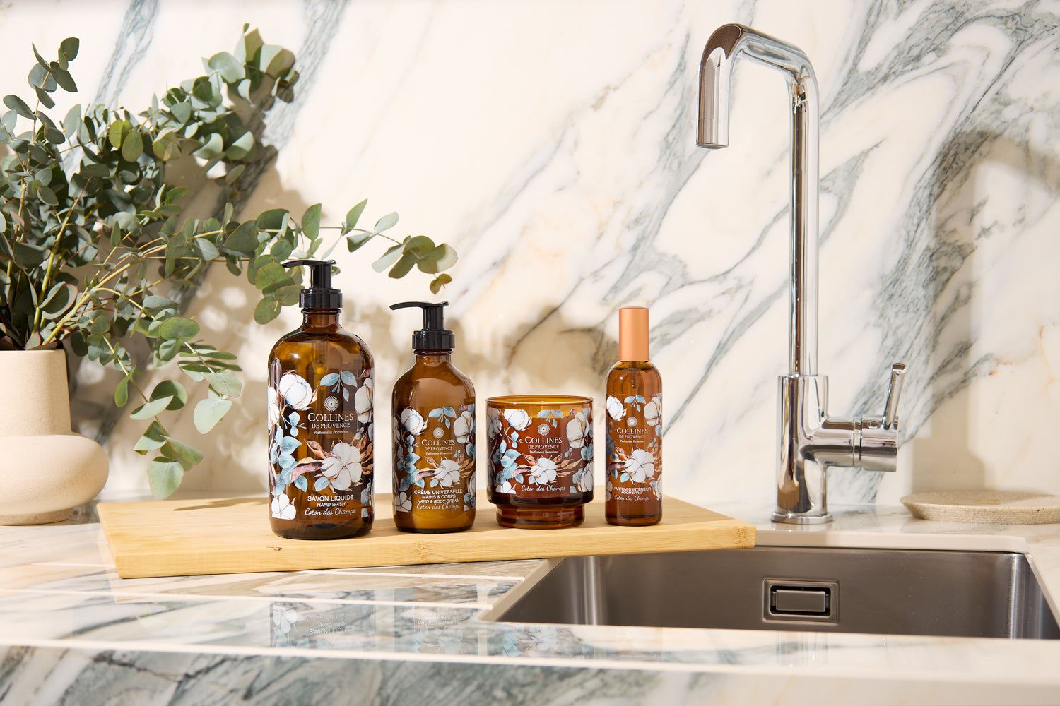 Set of Collines De Provence cotton breeze collection on a kitchen counter with a marble backsplash.
