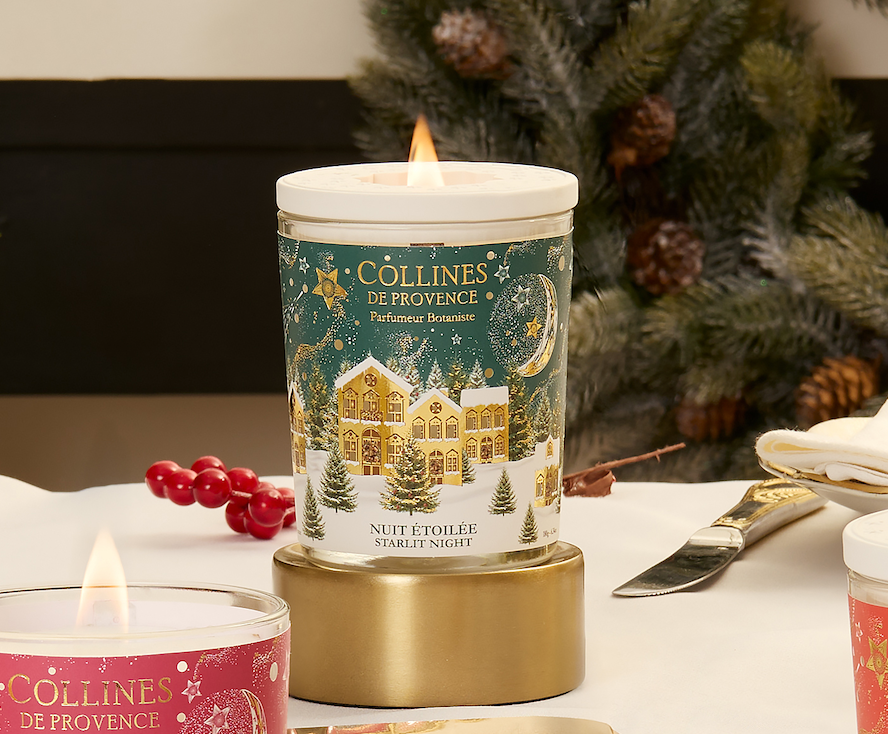 Collines de Provence starlit night scented candles with festive design on a table with a Christmas tree in the background