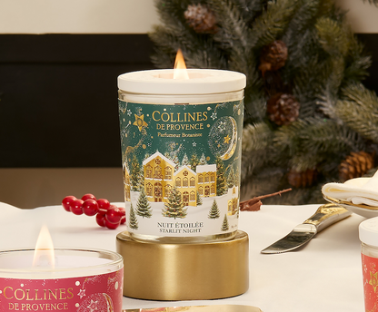 Collines de Provence starlit night scented candles with festive design on a table with a Christmas tree in the background
