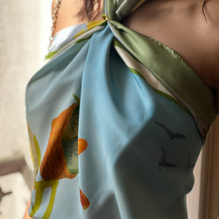 Close-up of a person wearing a colorful scarf with nature-themed design.