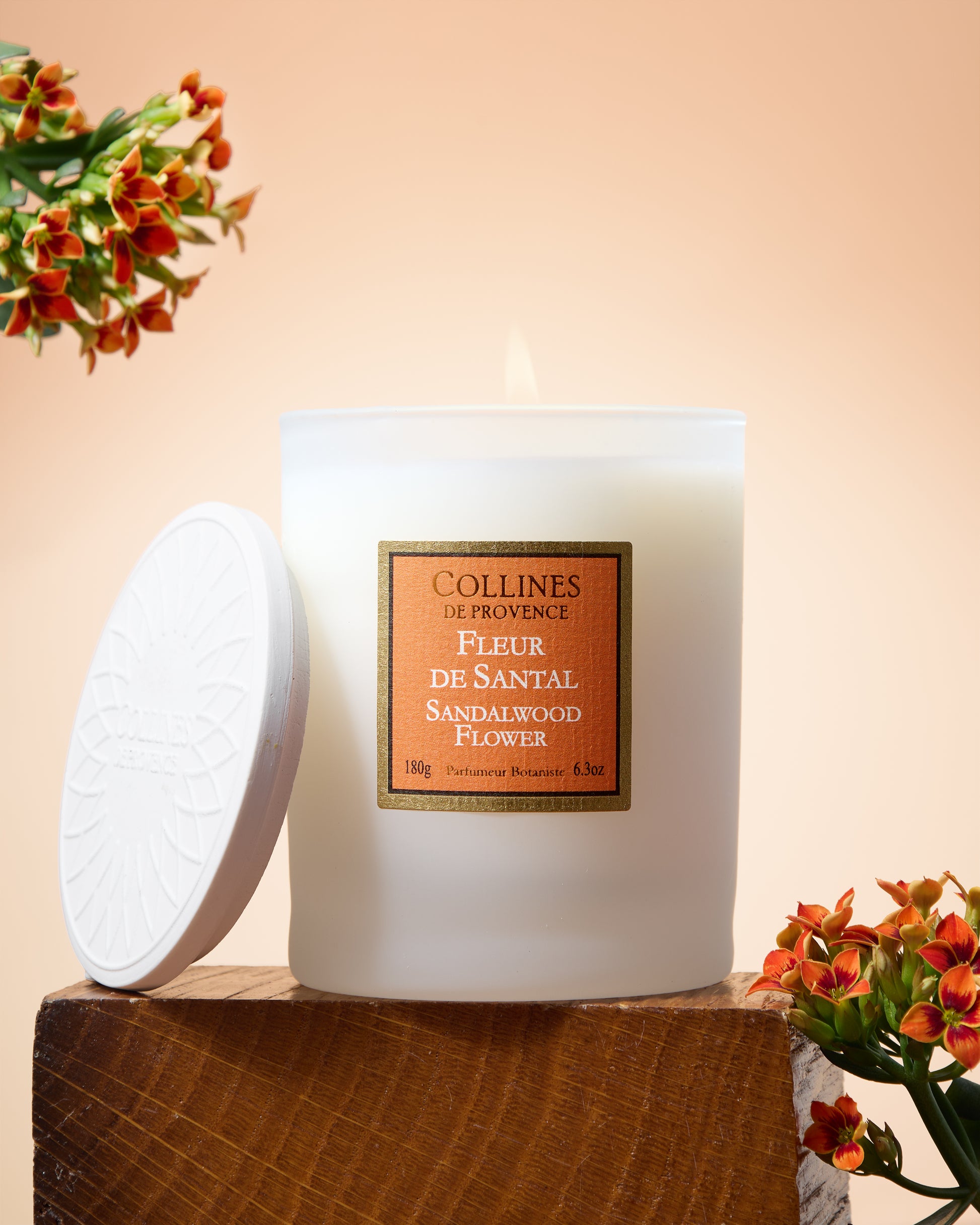 Collines de Provence Sandalwood flower scented candle with flowers on a wooden block