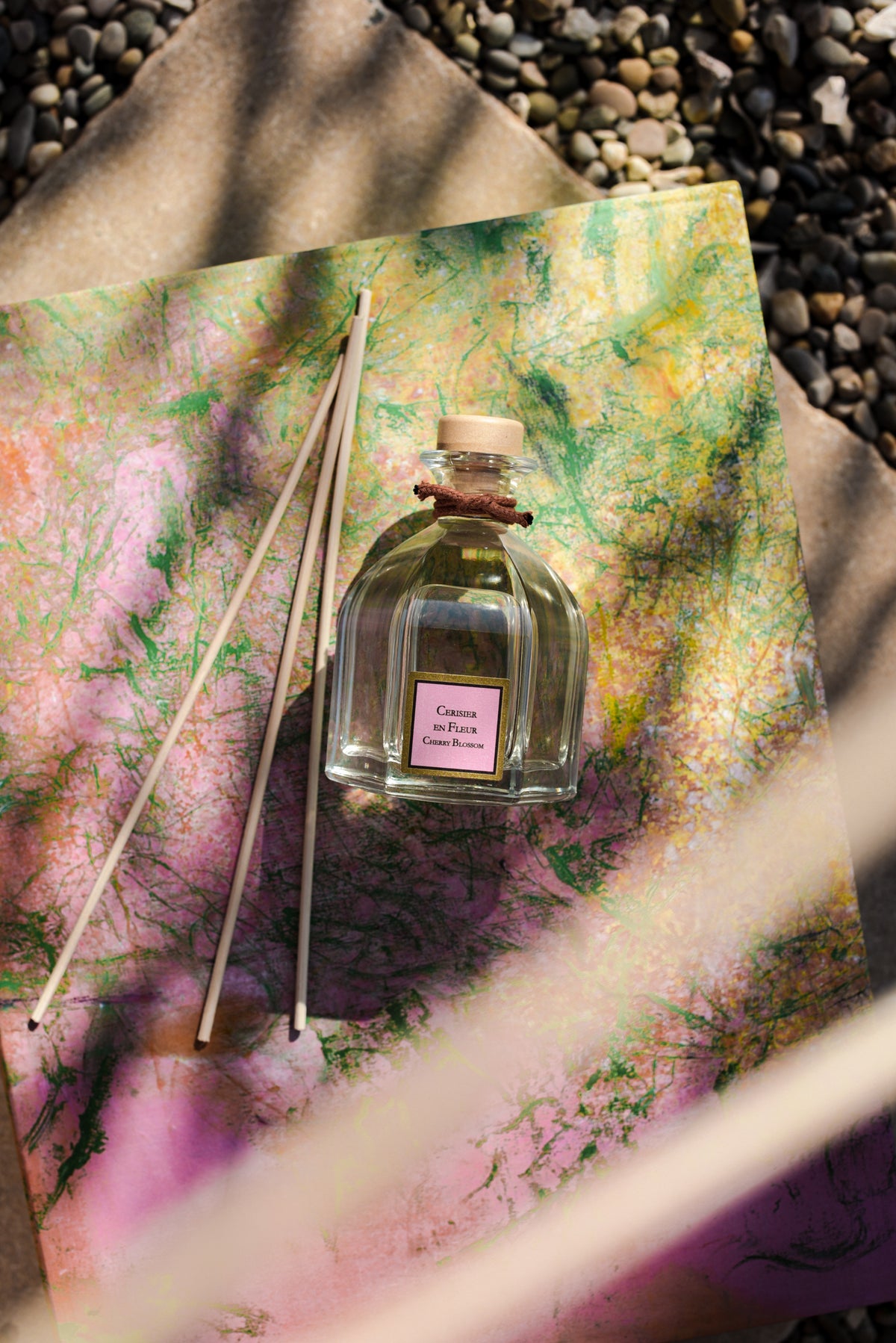 Cherry blossom Reed diffuser bottle with sticks on a textured surface
