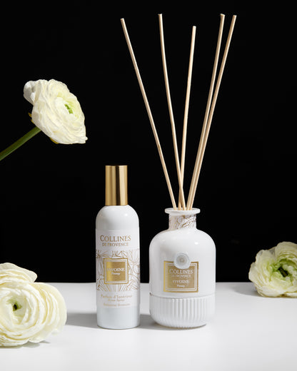 Collines de Provence peony diffuser with reeds, room spray, and flowers on a white surface
