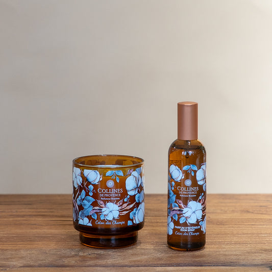 Collines de Provence Scented candle and room spray on a wooden surface with a beige background