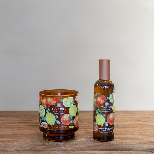 Collines de Provence citrus orchard glow scented candle and room spray on a wooden surface with a neutral background