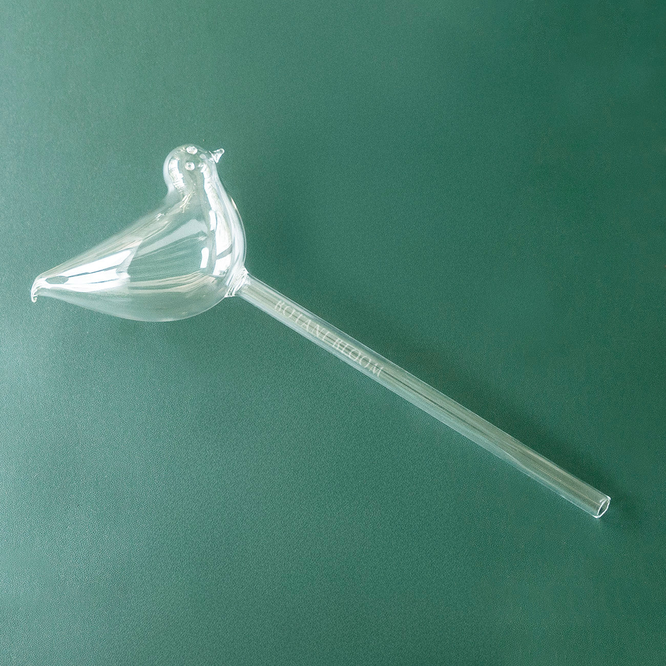 A clear glass bird shaped watering bulb designed to hold water, front view