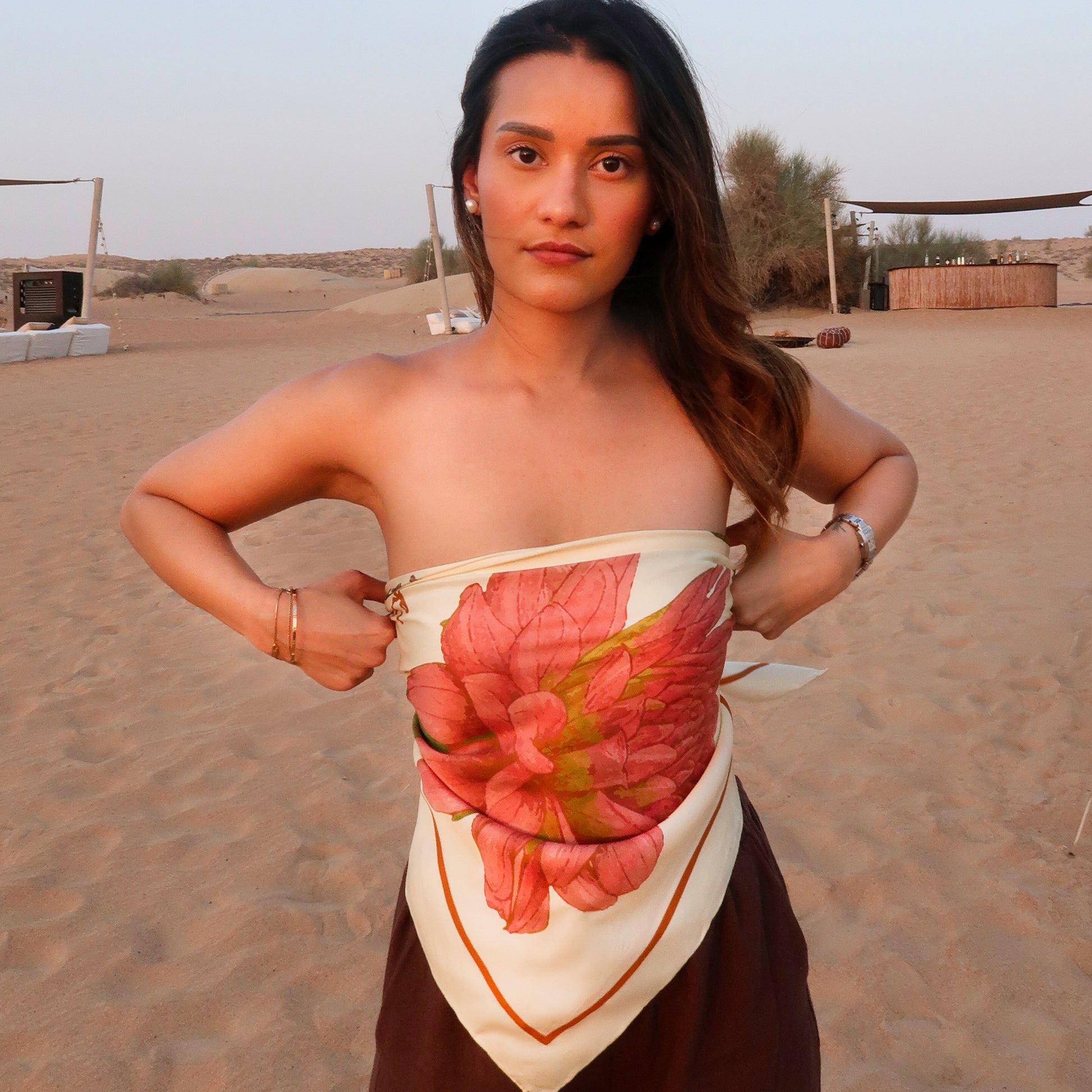 Woman wearing a silk scarf as a top with a floral pattern in a desert setting