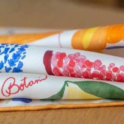 folded botani bloom scarf with floral patterns on a wooden surface
