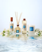Collines de Provence tiare flower diffuser, room spray, diffuser refill, and scented candle with floral arrangement on water