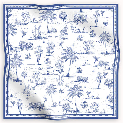 Blue and white patterned silk scarf with palm trees, flowers, and birds on a white background