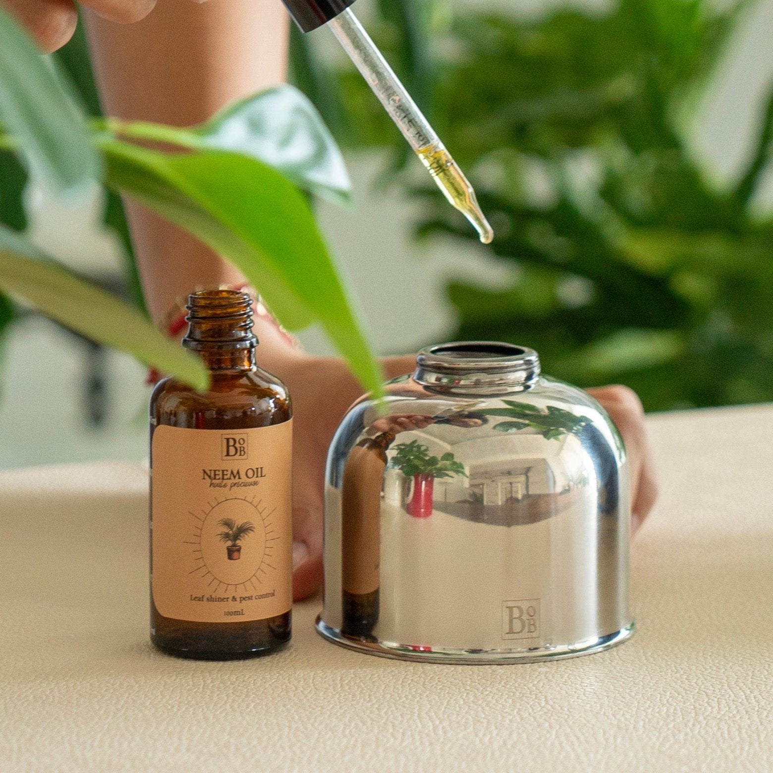 silver colored botani bloom plant mister, being filled with neem oil