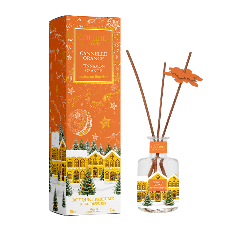 Botani Bloom cinnamon orange reed diffuser with packaging featuring a christmas snowy village design.