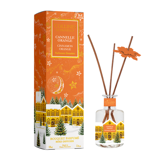 Botani Bloom cinnamon orange reed diffuser with packaging featuring a christmas snowy village design.