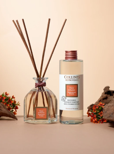 Collines de Provence sandalwood flower reed diffuser and diffuser refill bottle on a beige background