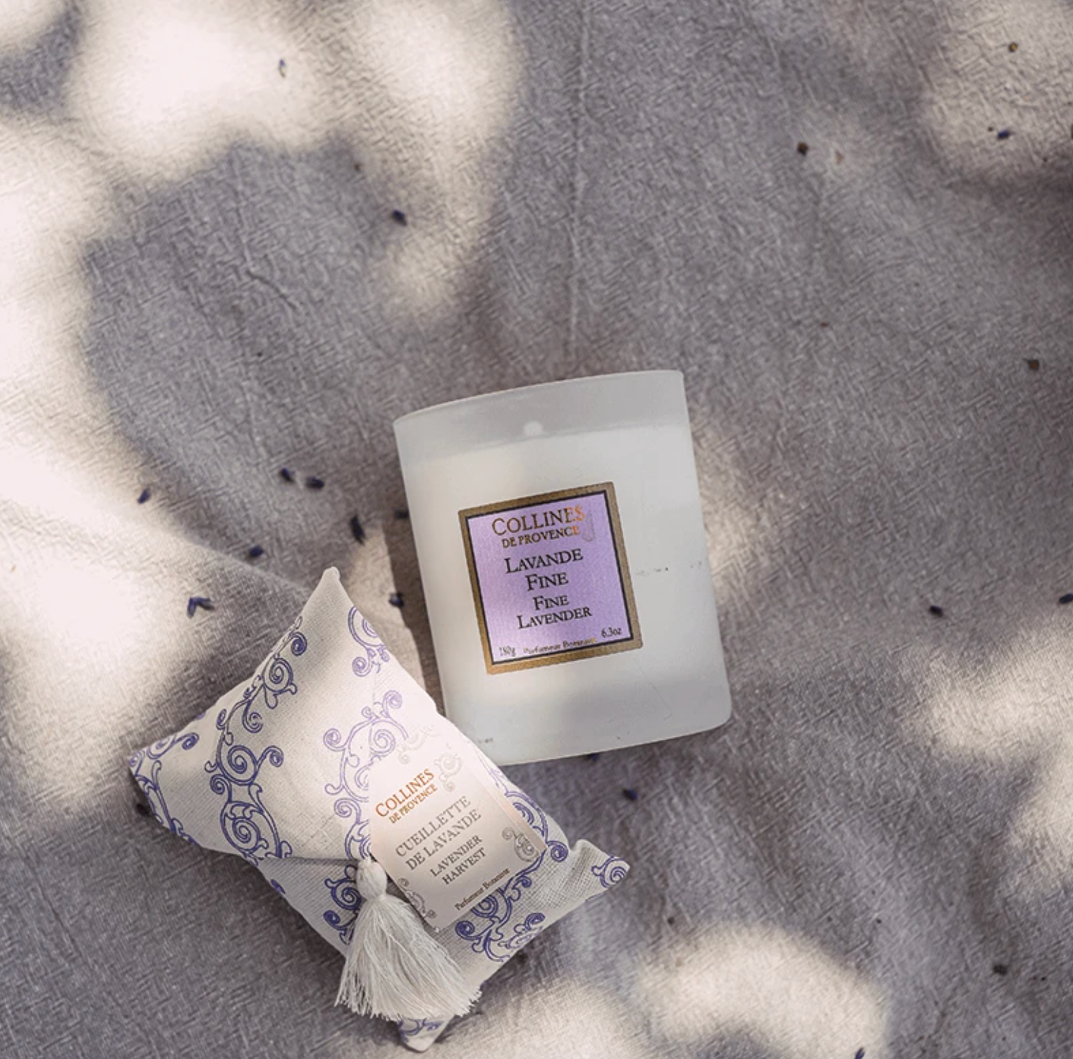 Collines de provence fine lavender scented candle on a textured surface with sunlight casting shadows