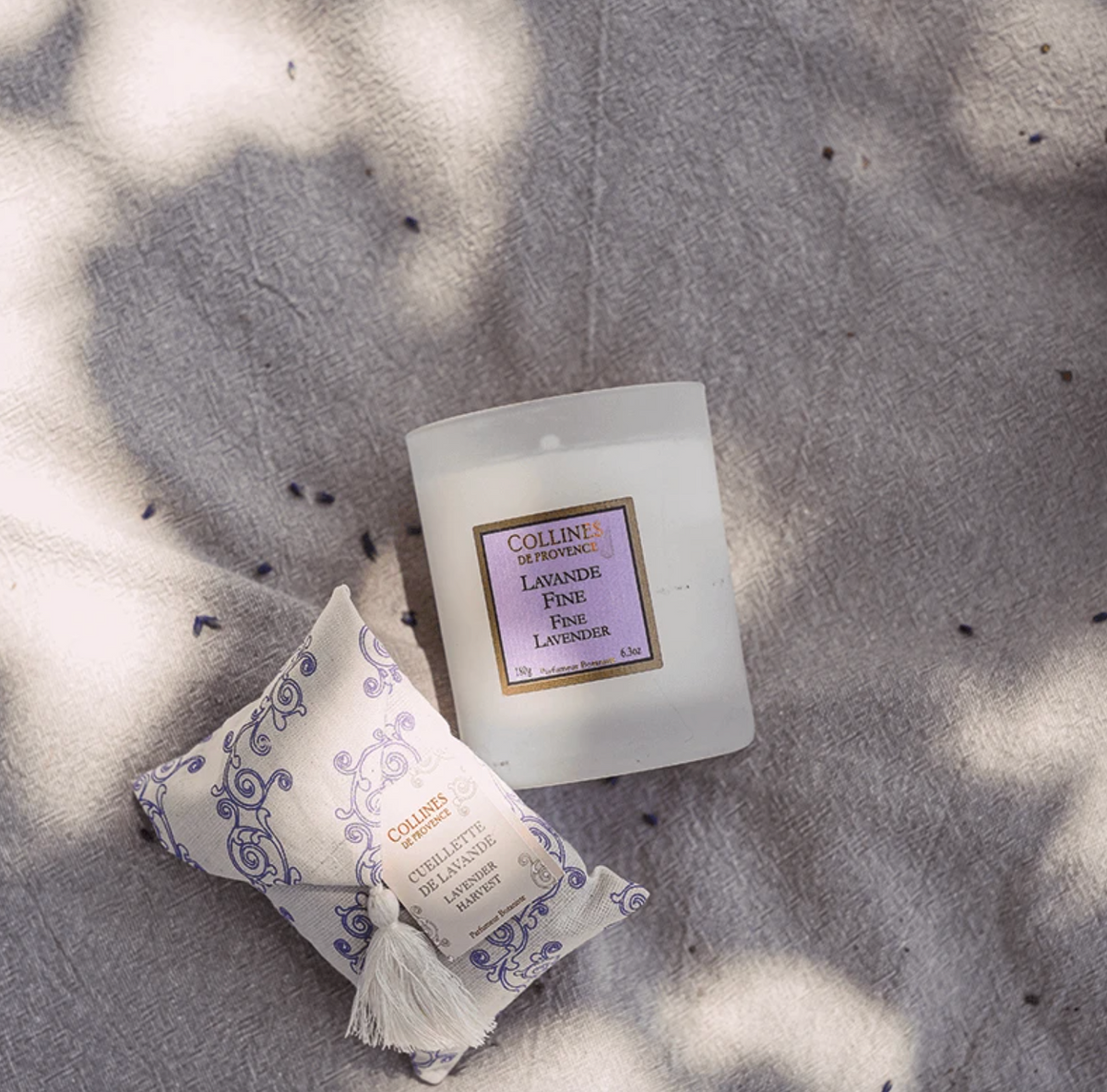 Collines de provence fine lavender scented candle on a textured surface with sunlight casting shadows