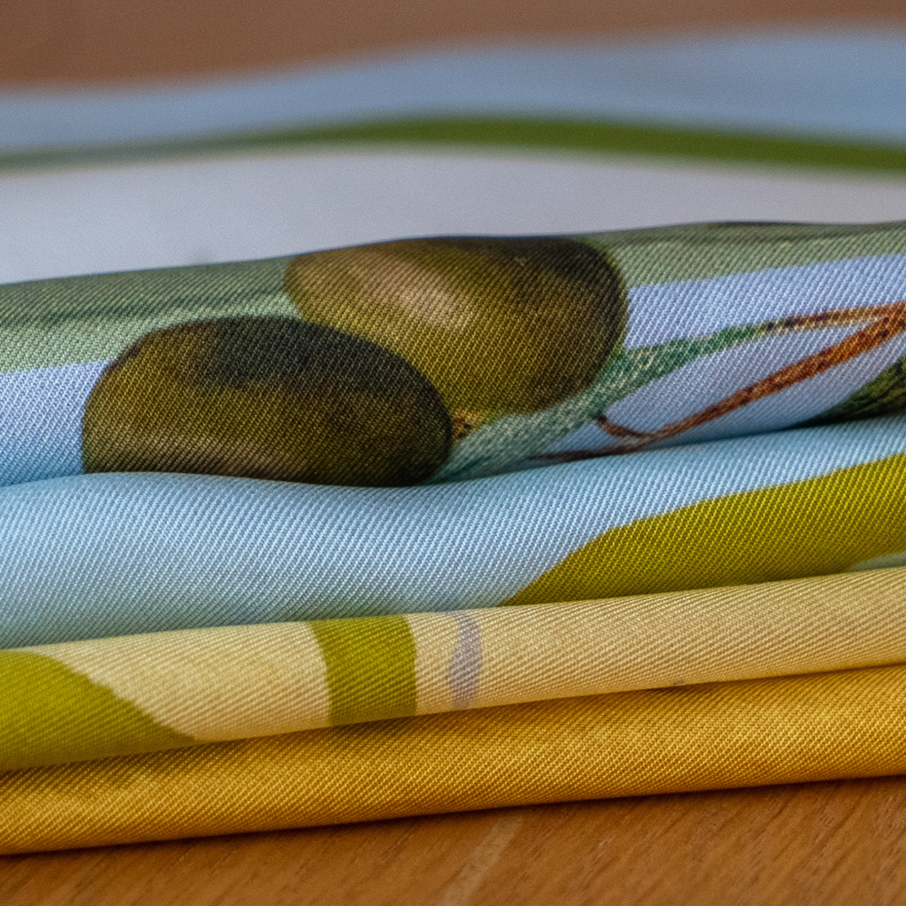 Stack of colorful scarves on a wooden surface